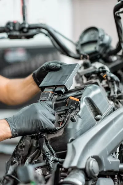 Hands working on a motorcycle, inspection reference